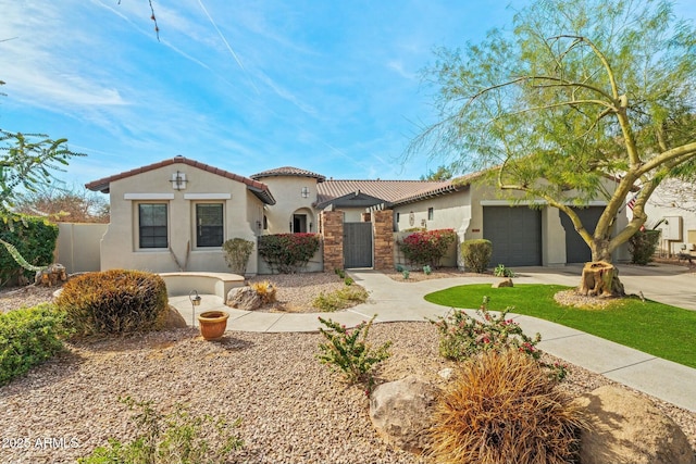 mediterranean / spanish home with fence, a garage, concrete driveway, a tile roof, and stucco siding