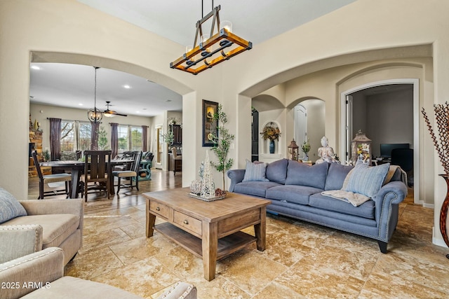 891 W Palo Brea Dr, Litchfield Park, AZ 85340 - living area featuring arched walkways, a notable chandelier, stone tile floors, and recessed lighting