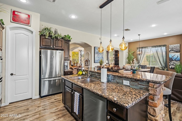 891 W Palo Brea Dr, Litchfield Park, AZ 85340 - kitchen featuring stainless steel appliances, visible vents, an island with sink, and dark brown cabinets