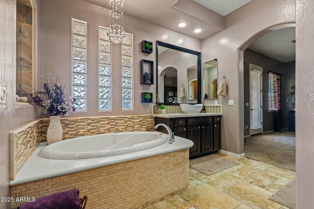 891 W Palo Brea Dr, Litchfield Park, AZ 85340 - bathroom with stone tile flooring, vanity, a bath, and baseboards