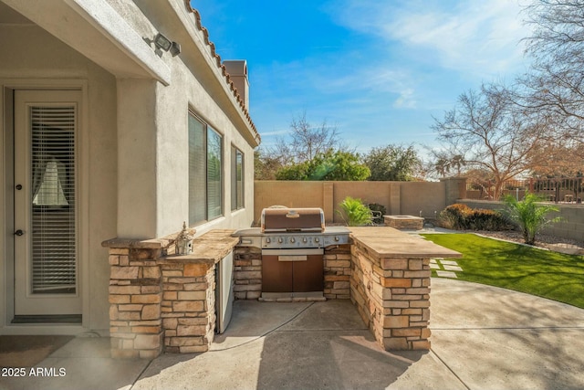 891 W Palo Brea Dr, Litchfield Park, AZ 85340 - view of patio featuring grilling area, a fenced backyard, and an outdoor kitchen