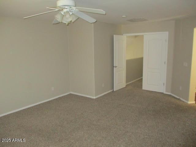 empty room featuring ceiling fan, carpet floors, and baseboards