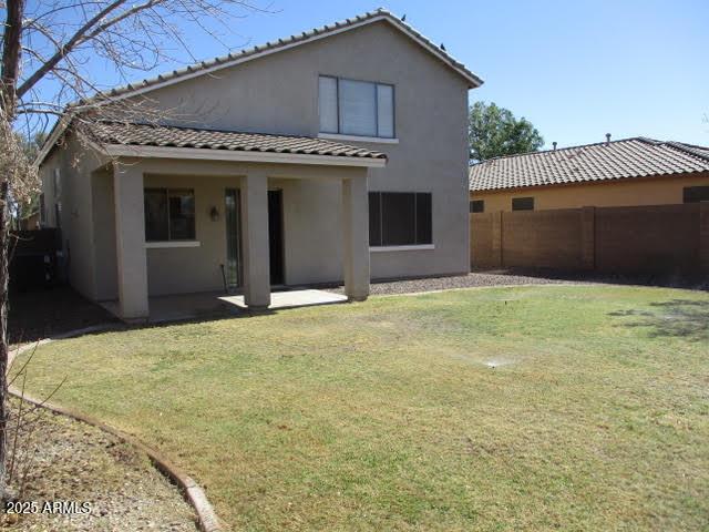 back of house featuring a yard, a patio area, fence, and stucco siding