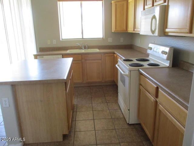 kitchen featuring white appliances, light tile patterned floors, a kitchen island, light countertops, and a sink