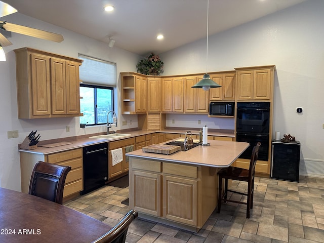 kitchen featuring sink, pendant lighting, lofted ceiling, a kitchen island with sink, and black appliances