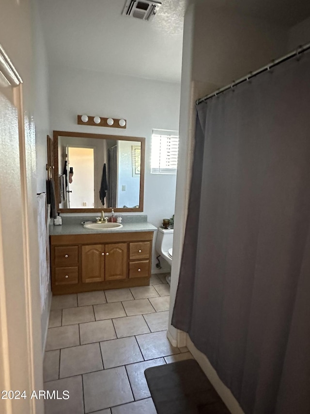 bathroom featuring tile patterned floors, vanity, and toilet