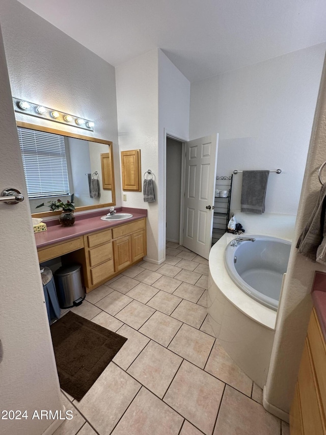 bathroom with tile patterned floors, vanity, and tiled tub