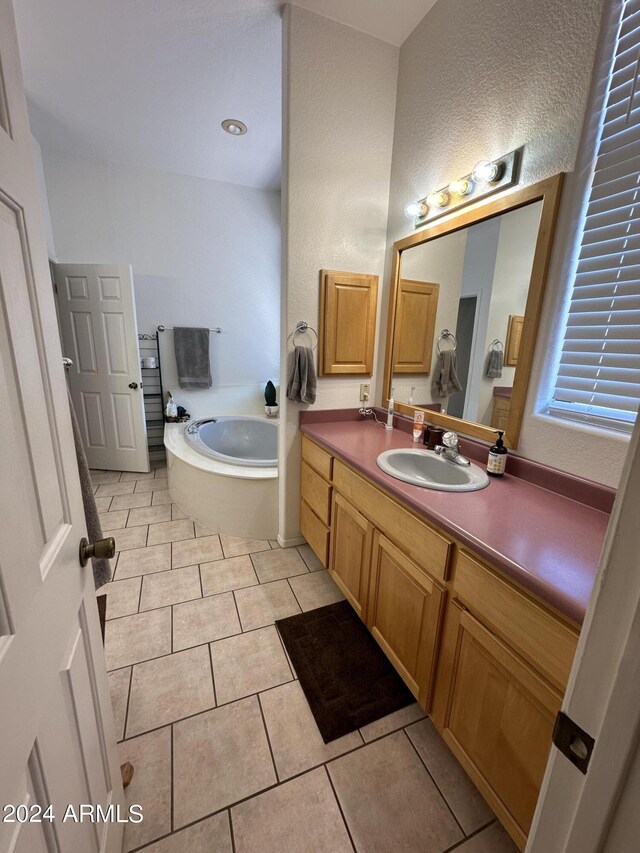 bathroom with tile patterned flooring, vanity, and a bathtub