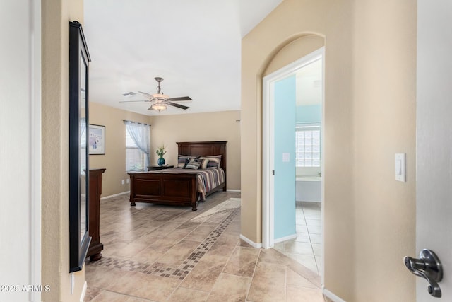 tiled bedroom with ceiling fan and multiple windows