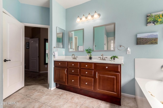 bathroom with tile patterned floors, a washtub, and vanity