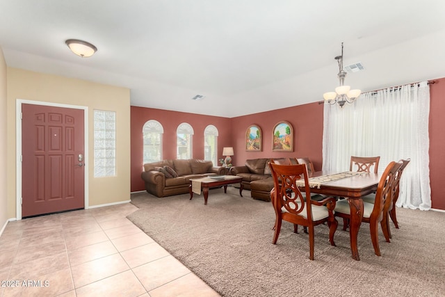 dining space with light colored carpet and an inviting chandelier