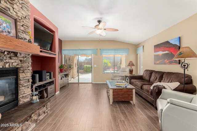 living room featuring ceiling fan, wood-type flooring, a fireplace, and lofted ceiling