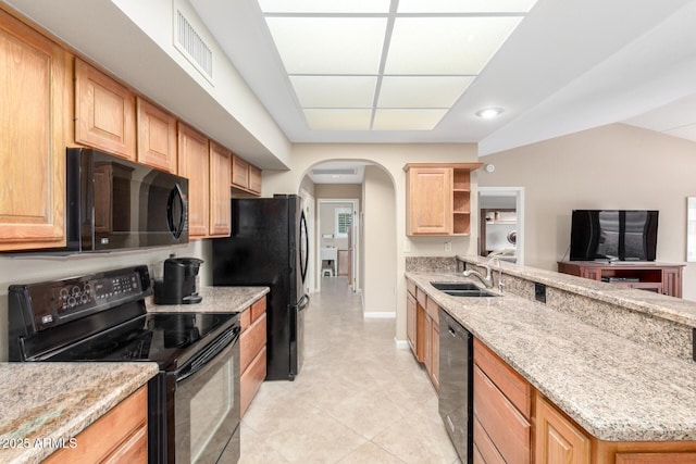 kitchen featuring sink, black appliances, and light stone countertops