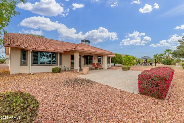 rear view of property with a gazebo and a patio