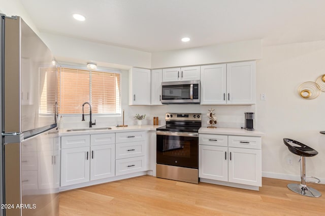 7432 N 43rd Ln, Glendale, AZ 85301 - kitchen with appliances with stainless steel finishes, white cabinetry, light countertops, light wood-type flooring, and recessed lighting