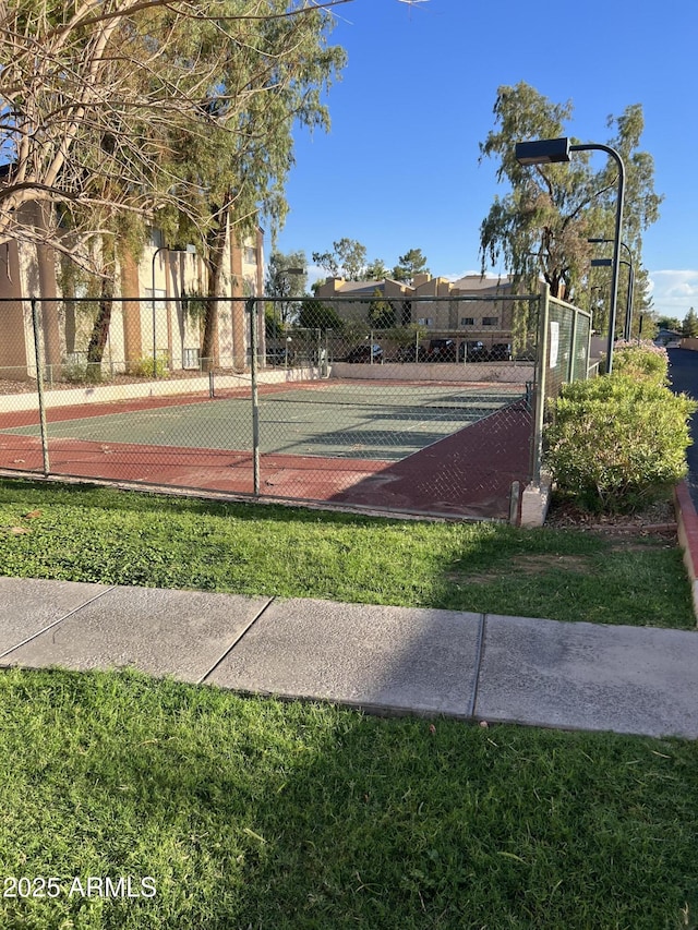 view of sport court with a lawn