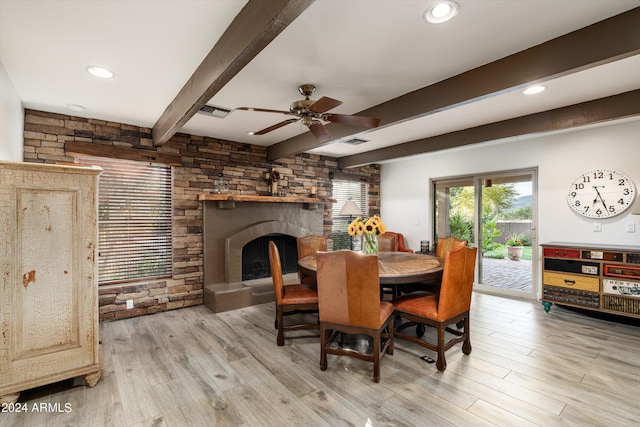 dining area with a fireplace, ceiling fan, beamed ceiling, and light hardwood / wood-style flooring