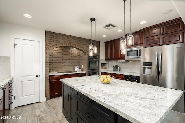 kitchen with tasteful backsplash, decorative light fixtures, stainless steel appliances, a center island, and light wood-type flooring