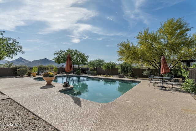 view of pool with a mountain view and a patio