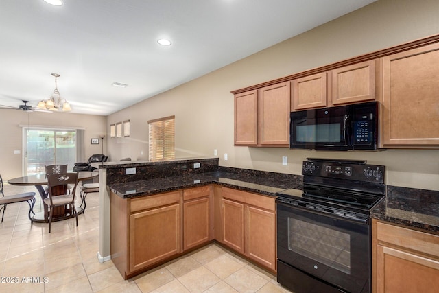 kitchen with dark stone counters, a peninsula, black appliances, and recessed lighting