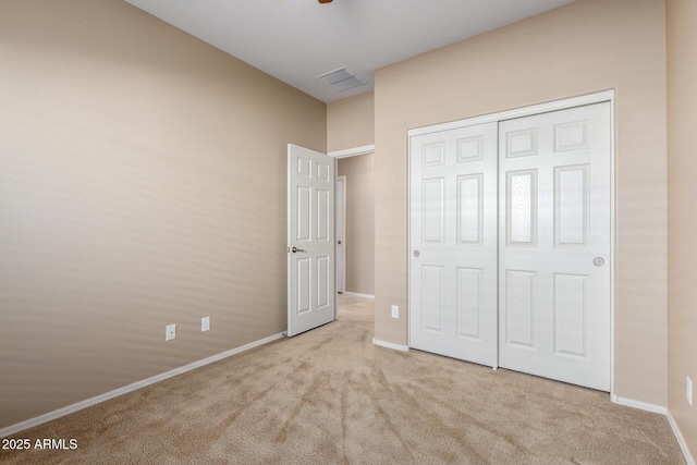 unfurnished bedroom with carpet floors, a closet, visible vents, and baseboards