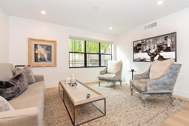 living area with baseboards, visible vents, wood finished floors, and recessed lighting