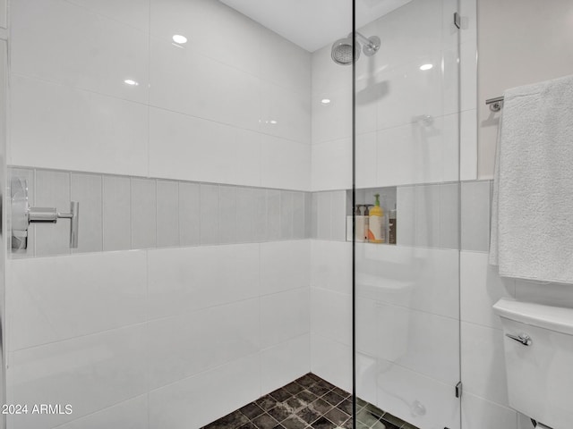 full bath featuring a tile shower and toilet