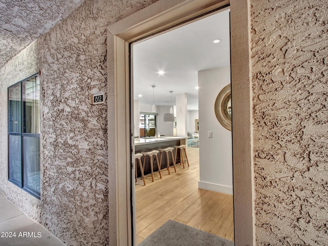 hall featuring light wood finished floors and recessed lighting