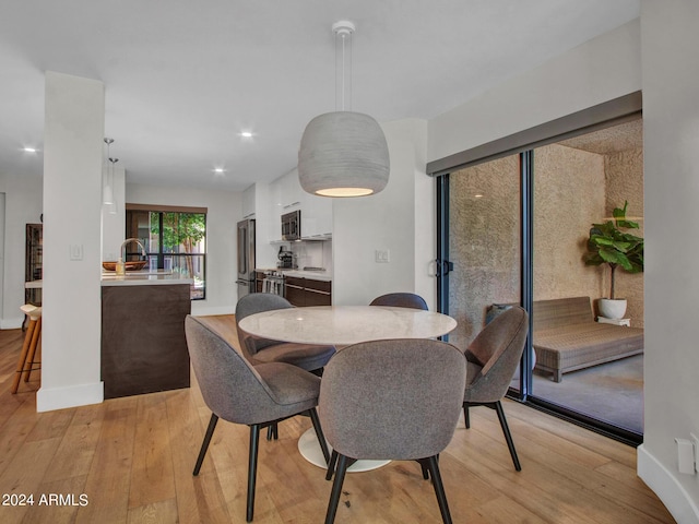 dining area featuring baseboards and light wood-style floors