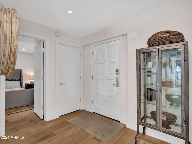 entryway featuring baseboards, wood finished floors, and recessed lighting