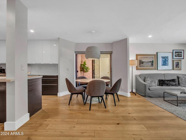 dining room featuring light wood-style floors, recessed lighting, and baseboards