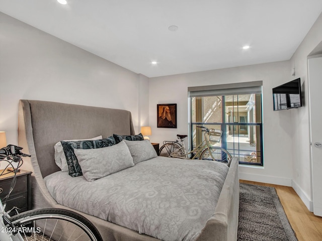 bedroom with recessed lighting, light wood-type flooring, and baseboards