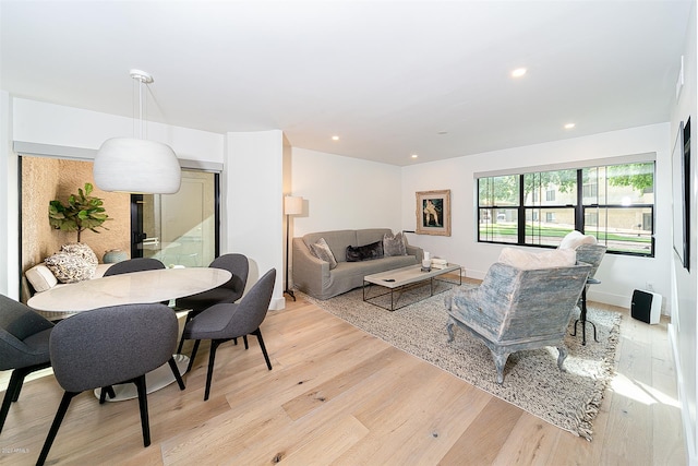 living area featuring light wood-type flooring, baseboards, and recessed lighting