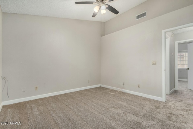 carpeted empty room featuring visible vents, ceiling fan, and baseboards