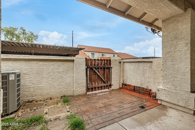 view of patio / terrace with fence, central AC, and a gate