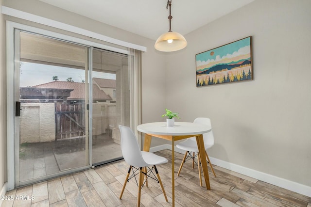 dining space featuring baseboards and wood finished floors