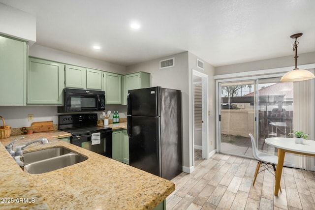 kitchen featuring green cabinetry, visible vents, black appliances, and a sink