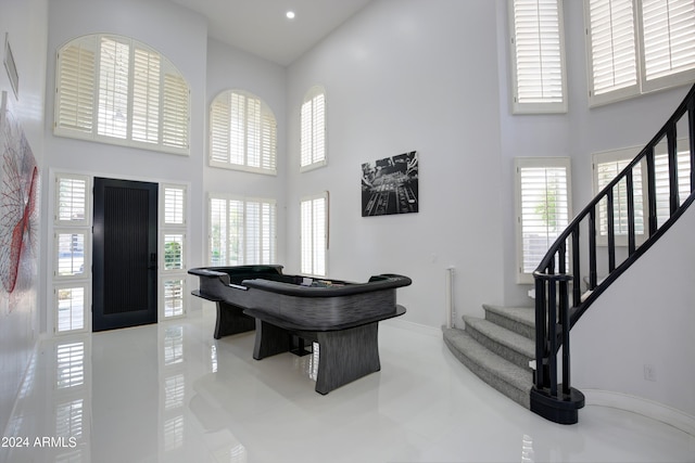 playroom with a high ceiling and light tile patterned flooring