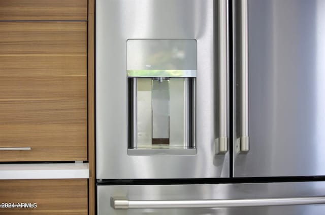 interior details featuring stainless steel refrigerator with ice dispenser