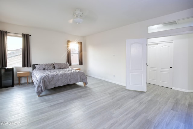 bedroom featuring light hardwood / wood-style floors, a closet, and ceiling fan