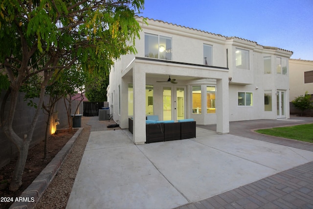 rear view of property with cooling unit, ceiling fan, an outdoor hangout area, and a patio area