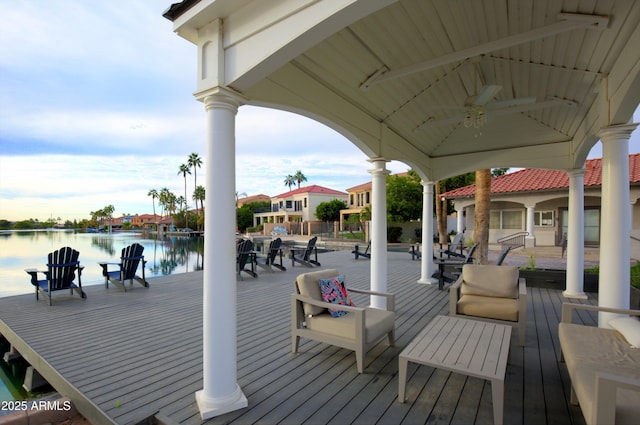 deck with a gazebo, ceiling fan, and a water view