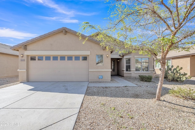 view of front of property featuring stucco siding, driveway, and a garage