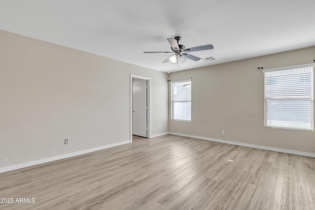 spare room featuring visible vents, baseboards, light wood-style flooring, and a ceiling fan