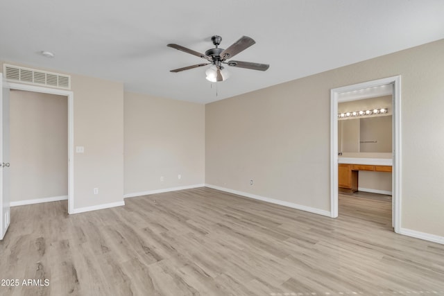 unfurnished bedroom featuring visible vents, light wood-style floors, baseboards, and connected bathroom