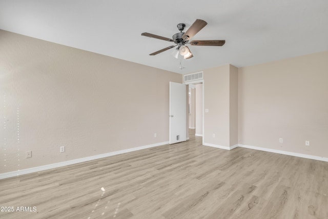 spare room with light wood-style flooring, a ceiling fan, visible vents, and baseboards