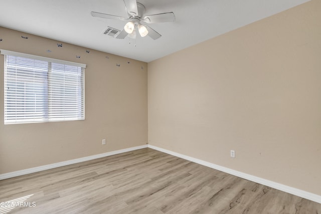 spare room with visible vents, baseboards, light wood-style flooring, and a ceiling fan