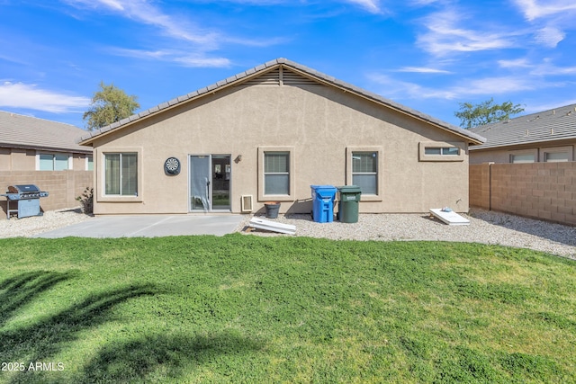 back of house with a patio area, a yard, a fenced backyard, and stucco siding