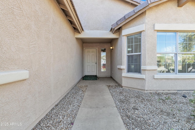 entrance to property with stucco siding