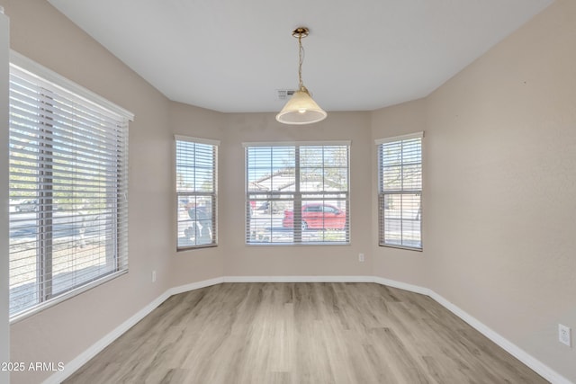 spare room with visible vents, baseboards, and light wood finished floors